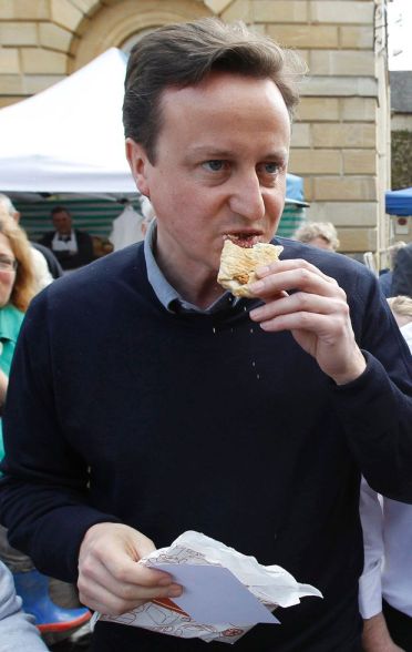 David+Cameron+eats+a+pastry+during+an+election+campaign+stop